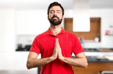 Evin içinde zen pozisyonundaki yakışıklı adam