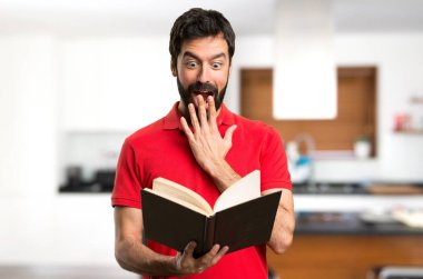 Evin içinde bir kitap okuma şaşırmış yakışıklı adam