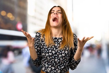 Güzel genç kız odaklanmamış arka plan üzerinde hayal kırıklığına uğramış