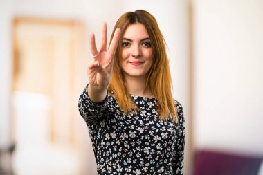 Güzel genç kız üç odaklanmamış arka plan üzerinde sayma