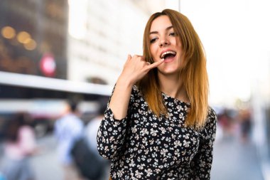 Güzel genç kız yapma telefon jest odaklanmamış arka plan üzerinde