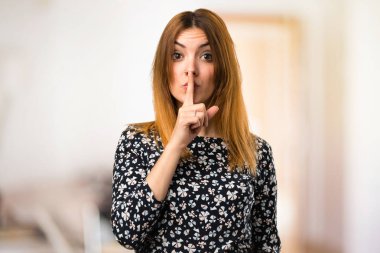 Güzel genç kız yapma sessizlik jest odaklanmamış arka plan üzerinde