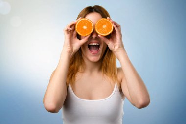Çılgın güzel genç kız gözlük odaklanmamış arka plan olarak portakal dilimleri giyiyor
