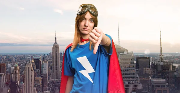 Pretty superhero girl making bad signal in a skyscraper city