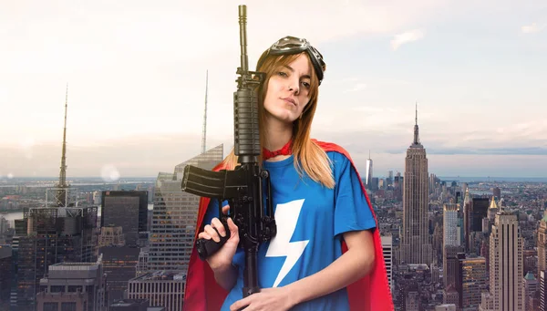 Pretty superhero girl holding a rifle in a skyscraper city