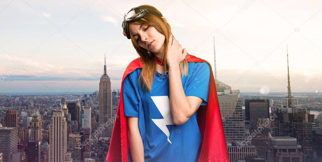 Pretty superhero girl with neck pain in a skyscraper city