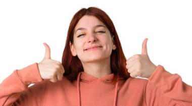 Jest Yaşasın vererek ve başarı izole beyaz arka plan üzerinde olmuştur çünkü gülümseyen pembe kazak ile genç Kızıl saçlı kız