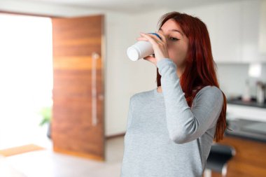 Paket servisi olan restoran kağıt bardak odaklanmamış arka plan üzerinde sıcak kahve içme genç Kızıl saçlı kız