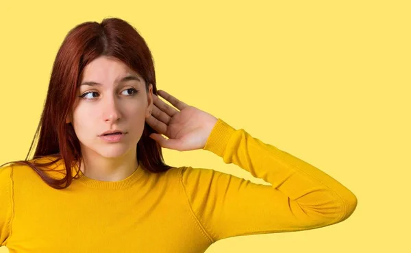 Chica Pelirroja Joven Con Suéter Amarillo Escuchando Algo Poniendo Mano — Foto de Stock