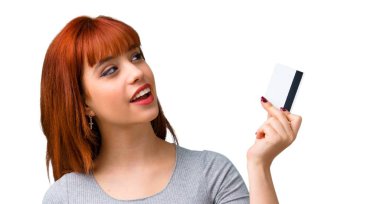 Bir kredi kartı tutan genç Kızıl saçlı kız