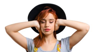 Her iki kulak elleriyle kapsayan şapka ile serin Kızıl saçlı kız