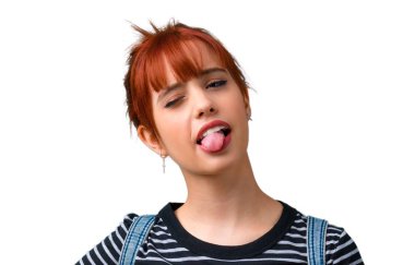 Dil komik göz olan kameraya gösteren genç öğrenci Kızıl saçlı kız