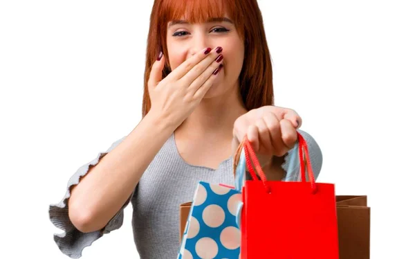 ショッピング バッグの多くを保持している若い赤毛の女の子 — ストック写真