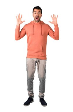 Adam, tam gövdesinde sürpriz ve şok yüz ifadesi ile pembe bir kazak. Ağzı açık çünkü izole beyaz arka plan üzerinde olanlar beklemek değil