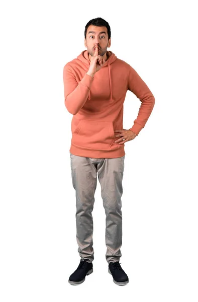 穿着粉红色运动衫的男子全身 显示关闭口和沉默手势在孤立的白色背景上把手指放在嘴里的迹象 — 图库照片
