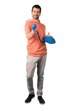 Adam tam vücut içinde konuşmak için vintage telefon izole beyaz arka plan üzerinde pembe bir kazak