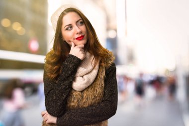 Kış kıyafetleri odaklanmamış arka plan üzerinde düşünme ile kız