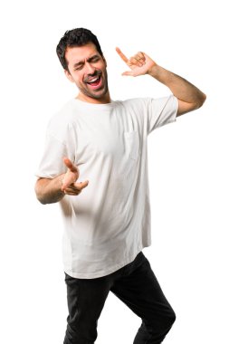 Beyaz gömlek ile genç adam zevk müzik izole beyaz zemin üzerinde bir partide dans