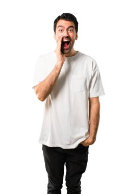 Geniş açık ağız ile bağırarak ve izole beyaz arka planda bir şey ilan beyaz gömlek ile genç adam