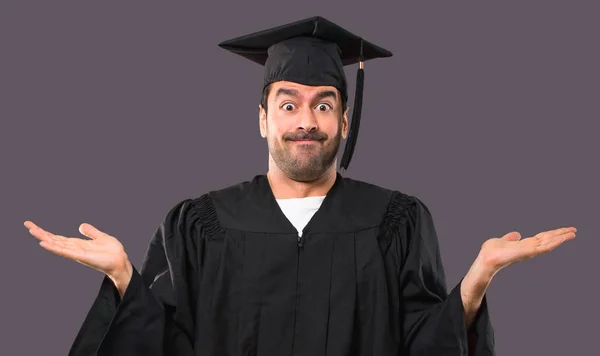 在他的毕业日大学的人有疑惑和混淆脸的表情 而举起手和肩膀紫色背景的不确定概念 — 图库照片