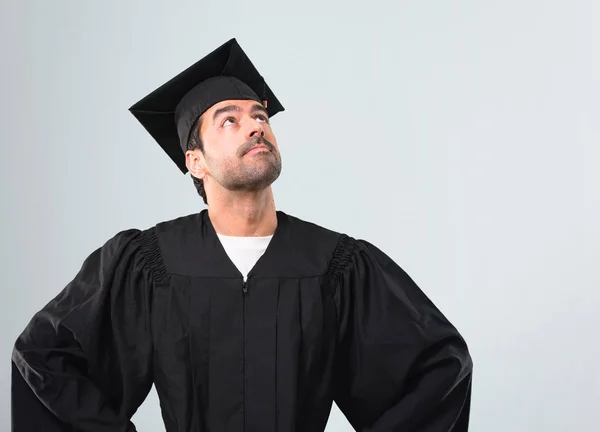 彼の卒業式の日大学スタンドと灰色の背景の上を男 — ストック写真