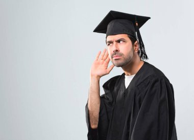 Adam bir şey kulak gri arka plan üzerine elini koyarak dinleme onun mezuniyet günü Üniversitesi Tarih