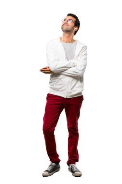 Gözlük ve müzik standı dinleme ve beyaz arka plan üzerinde gülümseyen süre seyir ile bir adam tam uzunlukta bir kadeh