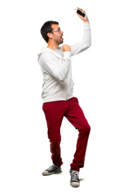 Beyaz arka plan üzerinde başarılı olmak için bir adam gözlük ve bir zaferini kutluyor ve sürpriz müzik dinleme tam uzunlukta bir kadeh