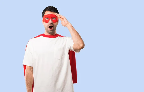 Superhero man with mask and red cape has just realized something and has intending the solution on isolated blue background