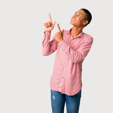 Harika bir fikir işaret parmağı ile işaret ve gri arka plan üzerinde ararken genç Afro-Amerikan adam