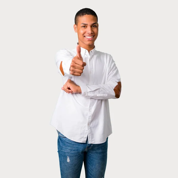 年轻的非洲裔美国人男子竖起大拇指的手势和微笑 因为有好的事情发生在灰色背景 — 图库照片