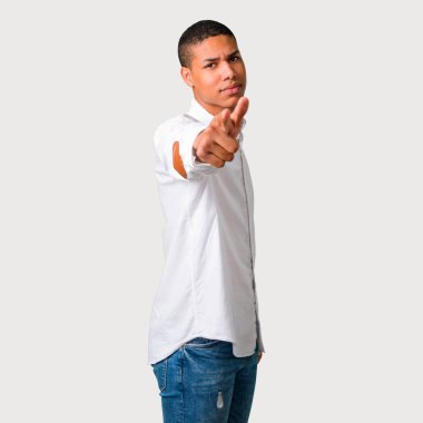 Genç Afro-Amerikan adam Öfkeli öfkeli jest olarak rahatsız. Kötü bir durum ve gri arka plan üzerine açık işaret tarafından hayal kırıklığına