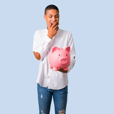 Beyaz gömlek izole mavi zemin üzerine büyük bir servet tutarken sürpriz genç Afro-Amerikan adamla