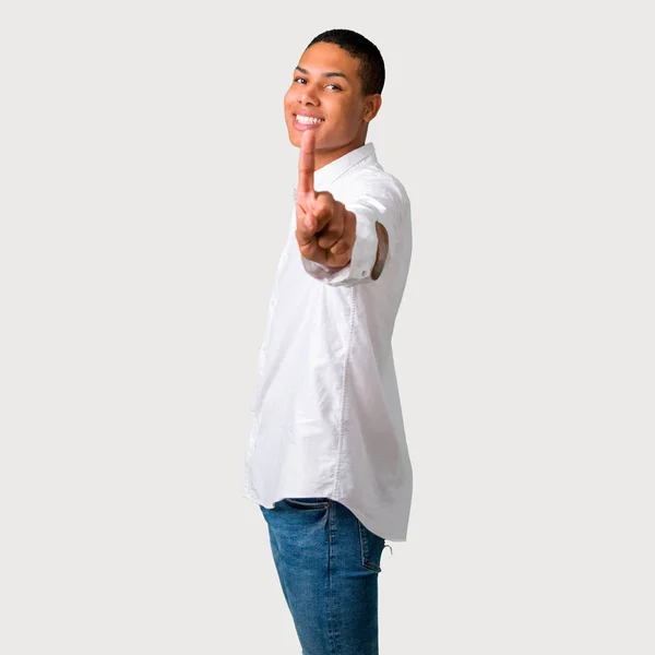 年轻的非洲裔美国人显示和举起手指在灰色背景最好的标志 — 图库照片