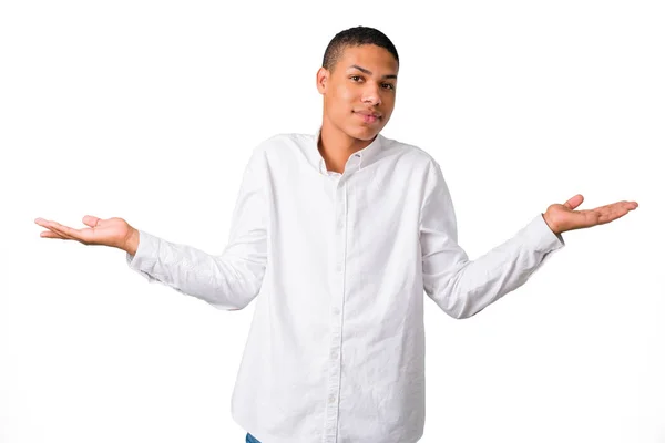 分離の白い背景の上肩と両手の手のひらを持ち上げながらジェスチャーを作る重要で白いシャツと疑問若いアフリカ系アメリカ人 — ストック写真