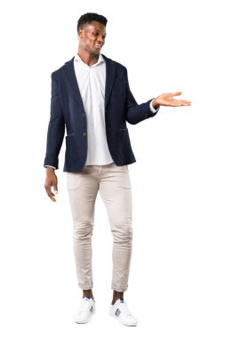 Afro-Amerikan yakışıklı görünümlü doğru beyaz arka plan üzerinde gülümseyen yaparken bir ürün ya da bir fikir sunan bir ceket tam vücut