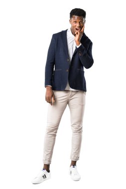 Tam vücut yakışıklı Afro-Amerikan adamın şaşırttı ve doğru bakarken şok bir ceket giyiyor. Beyaz arka plan üzerinde etkileyici yüz duygu