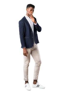 Tam vücut yakışıklı Afro-Amerikan adamın parmağını ağzına beyaz zemin üzerine koyarak ağız ve sessizlik bir jest kapanış bir işaret gösteren bir ceket