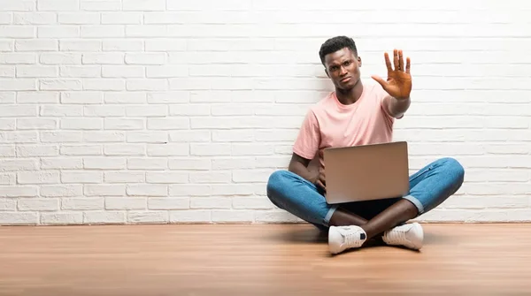 Hombre Afroamericano Sentado Suelo Con Portátil Haciendo Gesto Parada Con — Foto de Stock