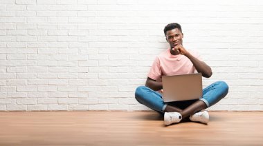 Onun laptop ile katta oturan Afro Amerikan adam öksürük ile acı ve kötü hissediyor