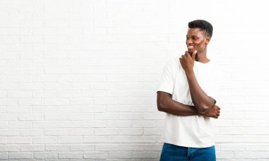 Koyu tenli adam ayakta ve tarafına el ile çeneme arıyorum.