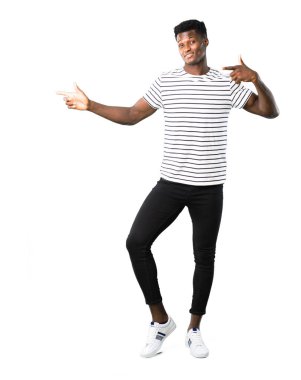 Tam vücut karanlık tarafına parmak işaret ve beyaz arka plan üzerinde gülümseyen bir ürün sunma çizgili gömlek ile adam derili