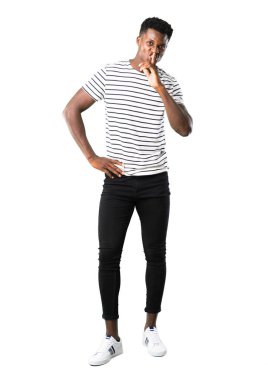 Çizgili gömlekli bir işaret parmağını ağzına beyaz zemin üzerine koyarak ağız ve sessizlik bir jest kapanış gösteren ile adam tam vücut karanlık tenli