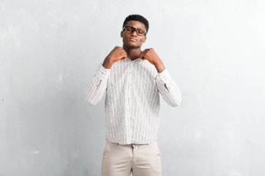 Dokulu gri duvara poz gözlüklü genç afro Amerikalı adam