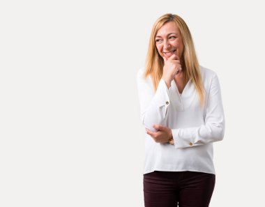 Orta yaş ayakta ve çene izole gri arka plan üzerinde el ile tarafına bakıp beyaz gömlek sarışın kadınla