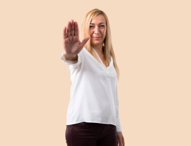 Orta yaş beyaz gömlek yapma dur jest eliyle izole koyu sarı arka plan üzerinde yanlış düşünüyor bir durum inkar sarışın kadınla