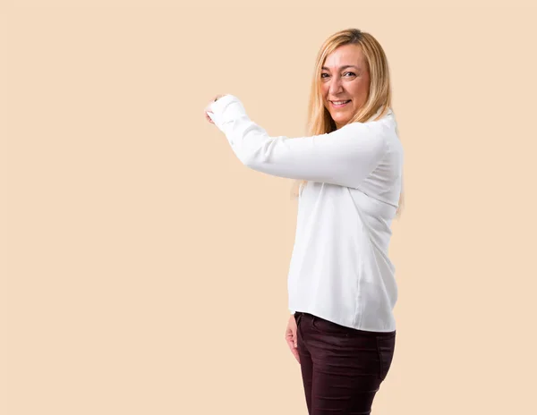 Mujer Rubia Mediana Edad Con Camisa Blanca Apuntando Hacia Atrás — Foto de Stock