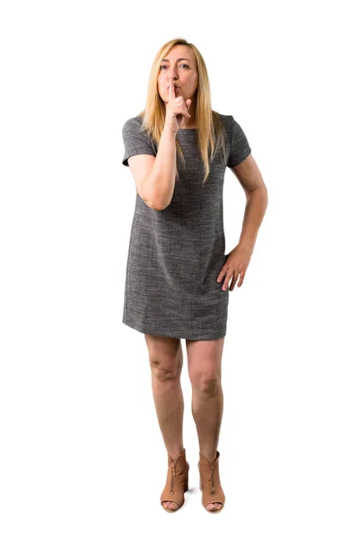 中年金发女人灰色礼服显示关闭的迹象和沉默的手势把手指在孤立的白色背景下的嘴 — 图库照片
