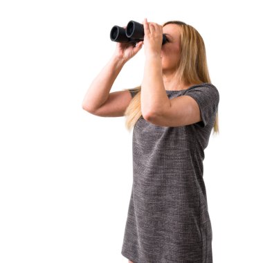 Orta yaş sarışın kadın ve seyir için bir şey uzaktan dürbünle izole arka plan beyaz