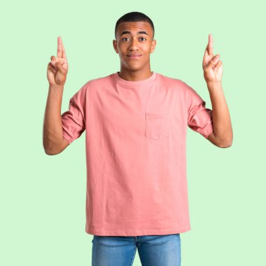 Karanlık adam en iyi dilek ve geçiş parmakları ile derili. Bir dilek yapma. yeşil arka plan izole